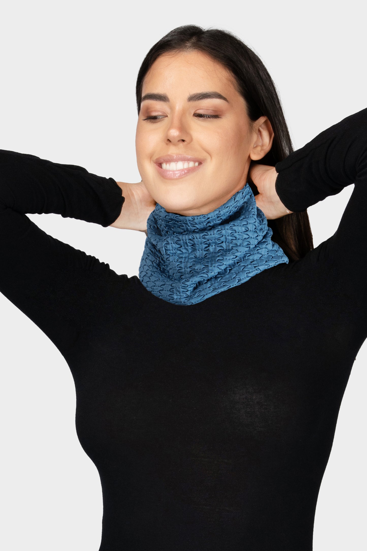 Donna sorridente che indossa scaldacollo colore teal