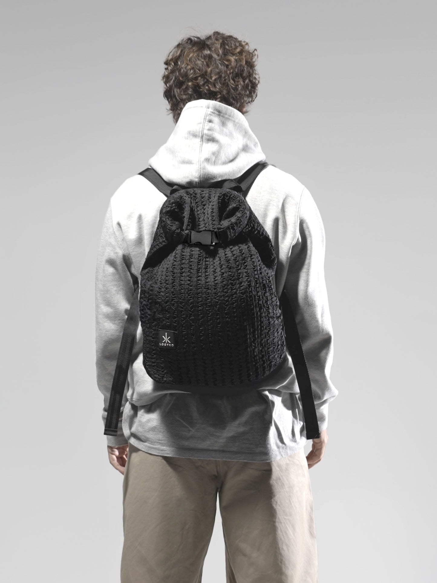 Zaino Helium di LOGYKO color nero indossato da un ragazzo di spalle
