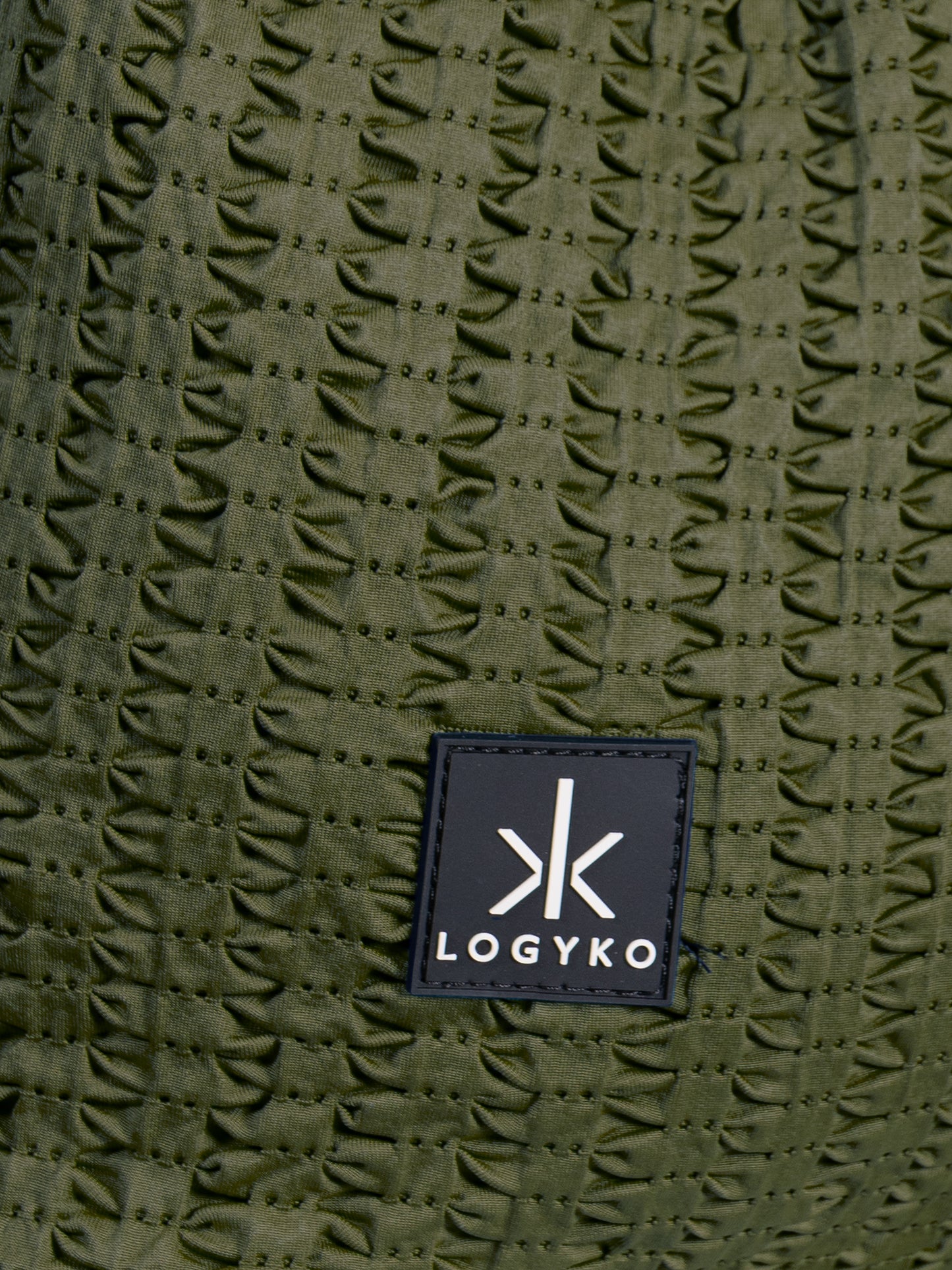 Dettaglio del logo cucito sul davanti dello Zaino Helium di LOGYKO color verde militare