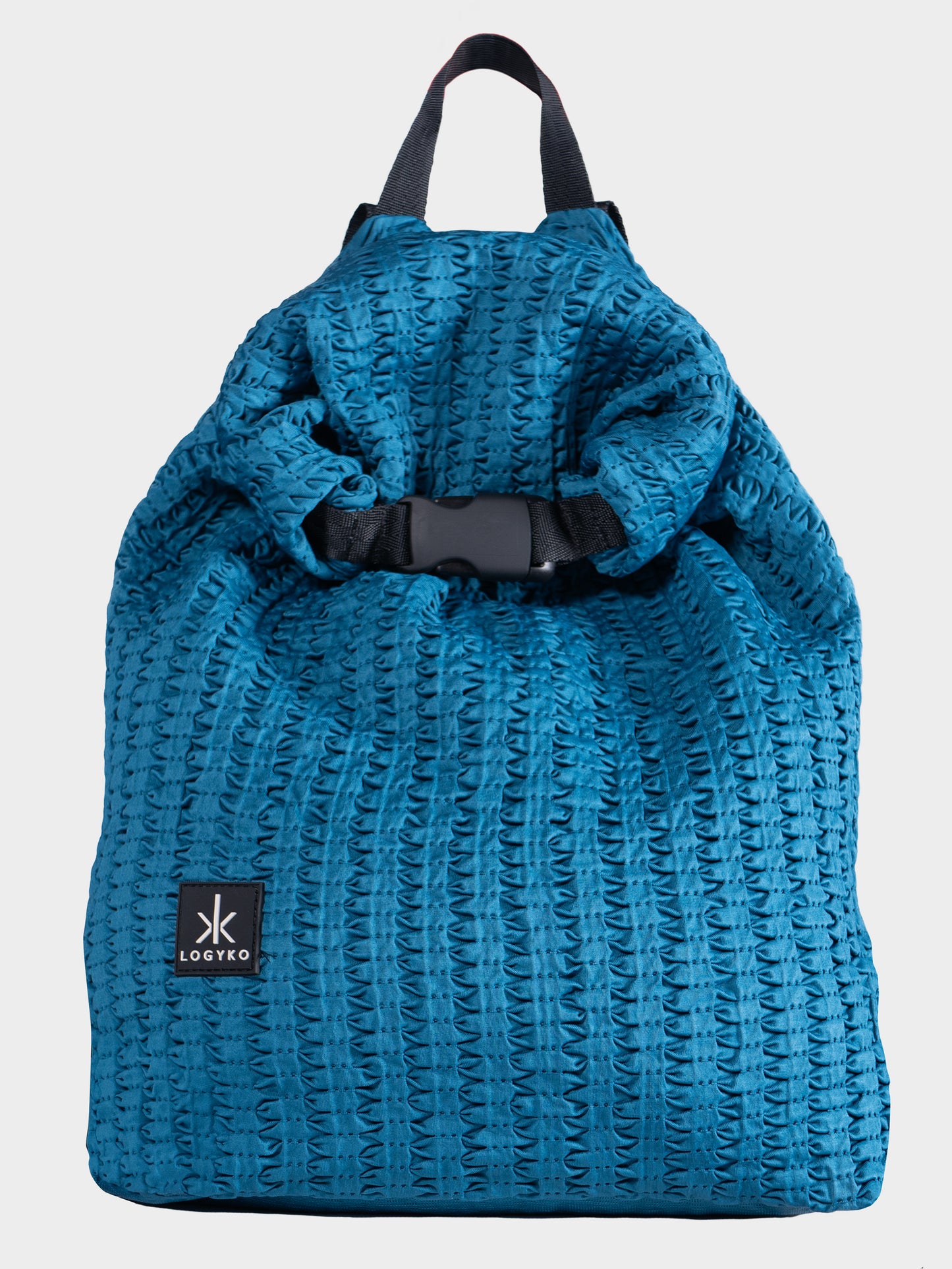 Zaino Helium di LOGYKO color teal visto frontalmente. Il tessuto morbido ha una trama 3D e una chiusura roll top