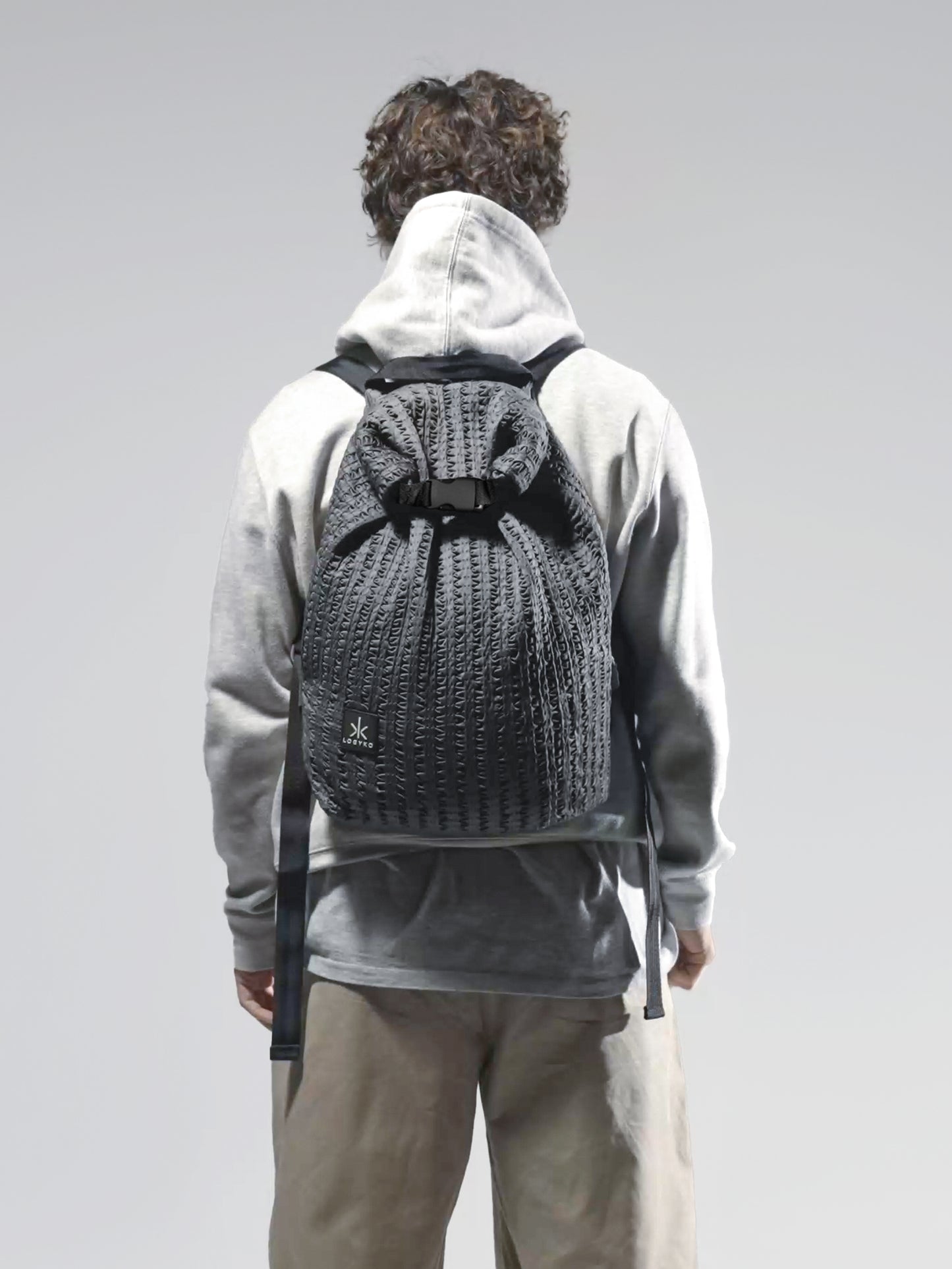 Zaino Helium di LOGYKO color grigio scuro indossato da un ragazzo di spalle