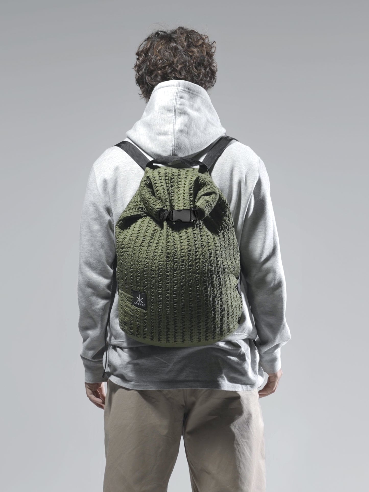 Zaino Helium di LOGYKO color verde militare indossato da un ragazzo di spalle