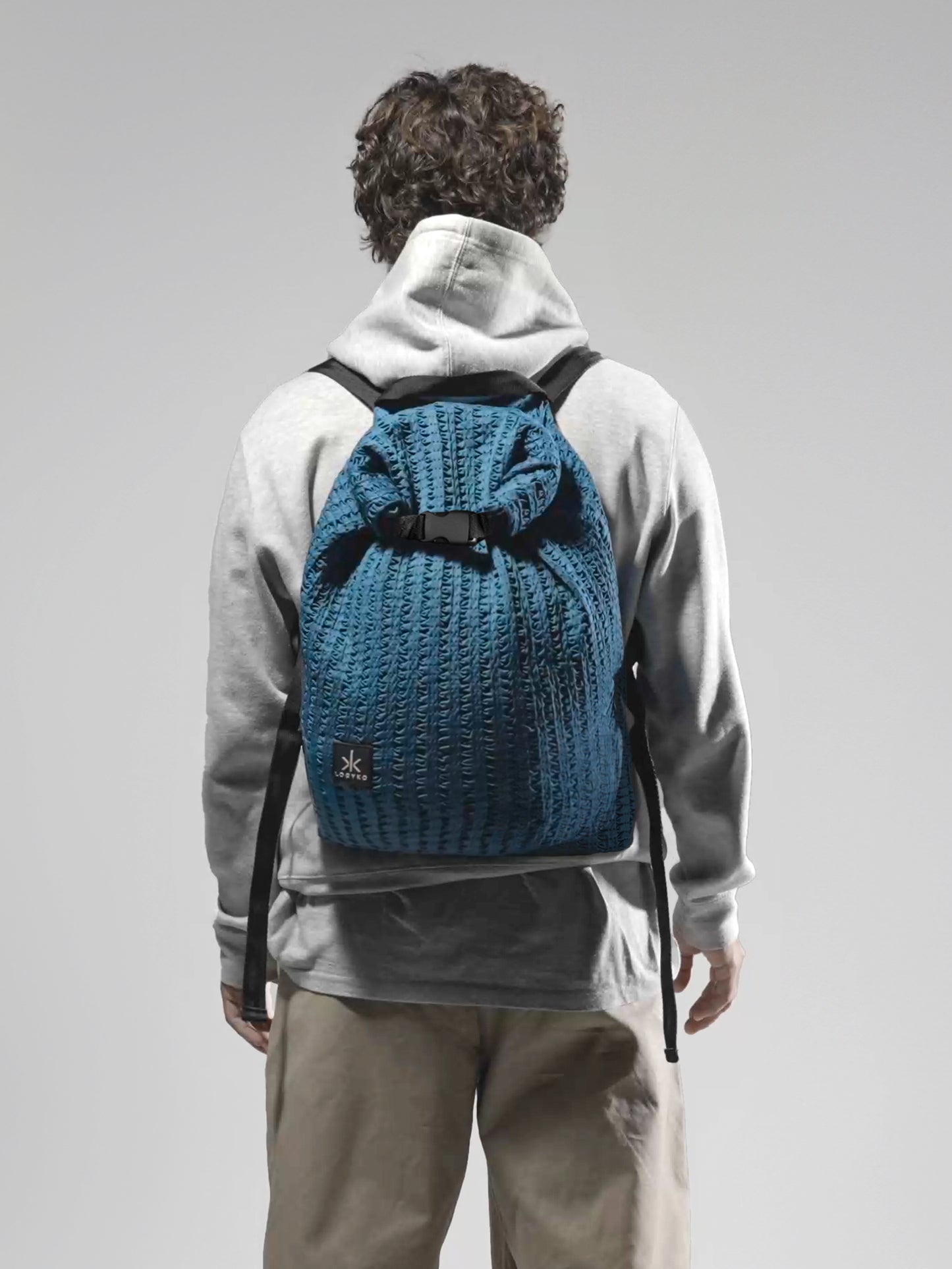 Zaino Helium di LOGYKO color teal indossato da un ragazzo di spalle